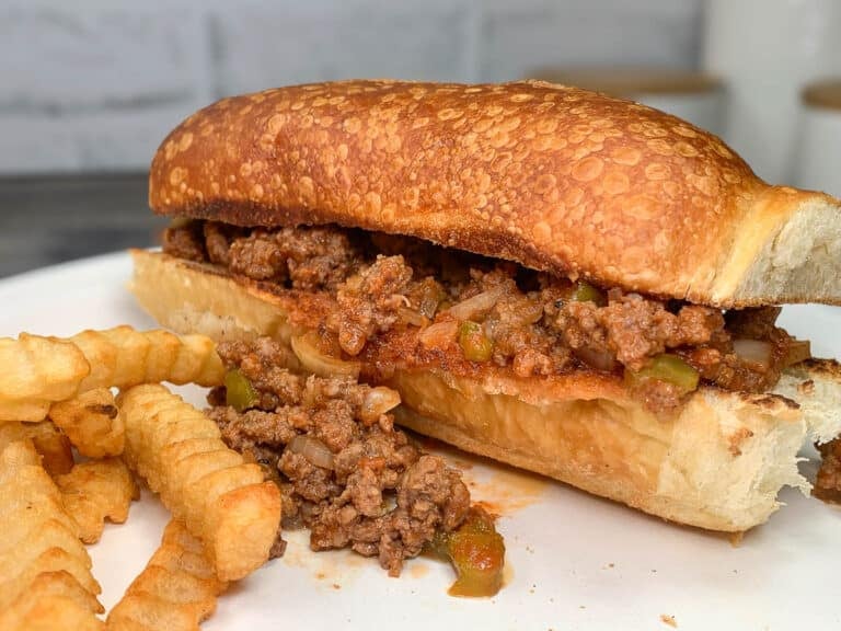 sloppy joe sandwich on a plate with french fries