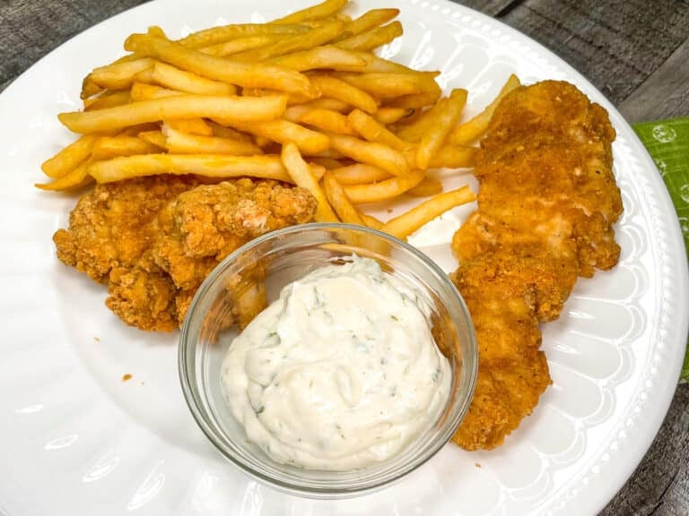 dill dipping sauce on a plate with fries and chicken tenders