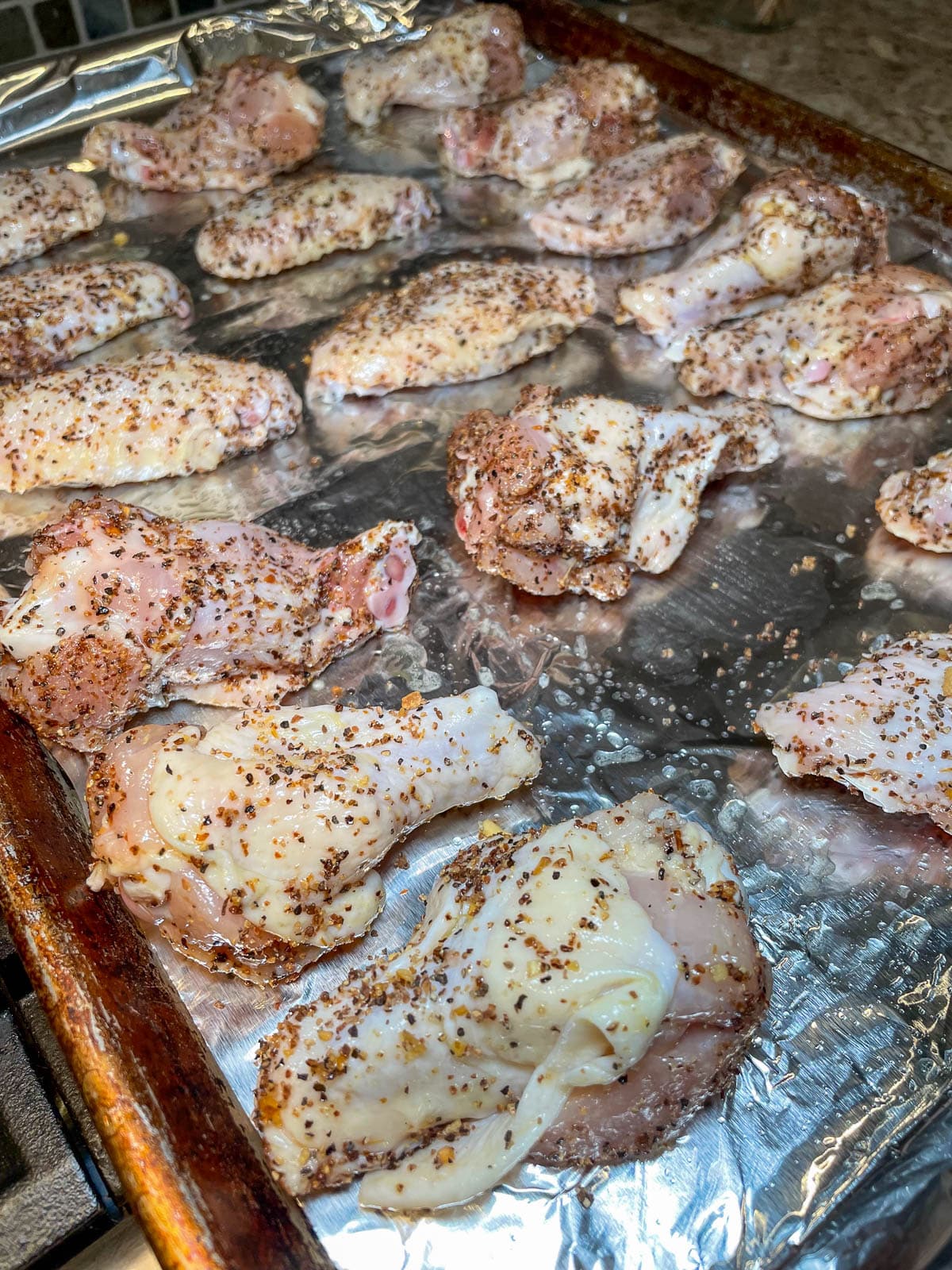 seasoned chicken wings on a baking sheet